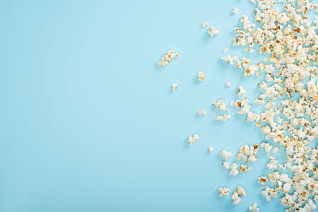 top view of scattered crispy popcorn on blue, cinema conceptの写真素材