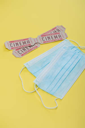 cinema tickets near medical masks on yellow, cinema conceptの写真素材