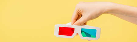 partial view of woman holding 3d glasses isolated on yellow, banner, cinema conceptの写真素材