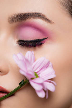 close up of sensual young woman with pink eye shadows holding flowerの写真素材