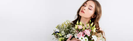 Young woman with closed eyes holding bouquet isolated on gray, banner