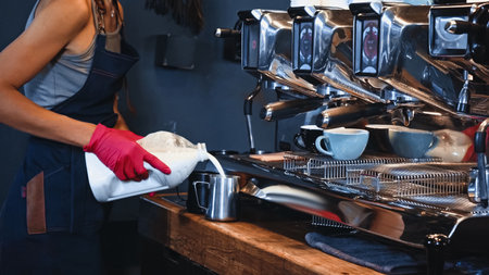 cropped view of barista pouring milk from carton boxの写真素材