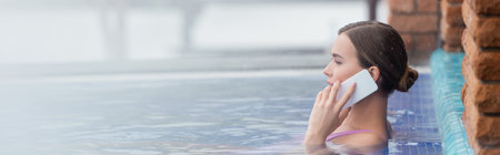 side view of woman in swimsuit talking on smartphone while bathing in outdoor swimming pool, banner