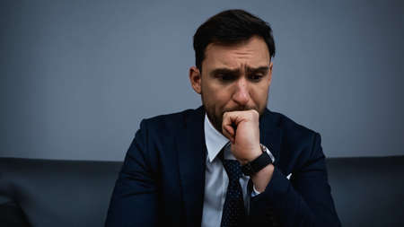 Upset businessman sitting in hotel roomの写真素材