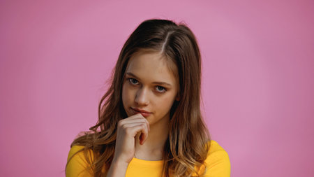teenage girl looking at camera isolated on pinkの写真素材