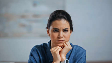 upset young woman looking at camera at home