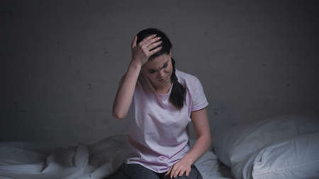 brunette young woman suffering from headache at night
