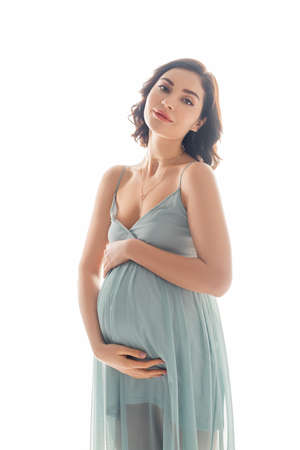 Pregnant woman looking at camera isolated on white