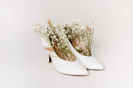 heeled shoes with tiny gypsophila flowers on whiteの写真素材
