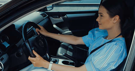 side view of happy young woman driving car