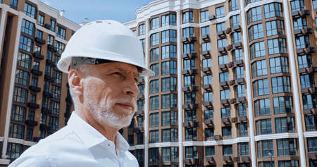 middle aged engineer looking away near building on backgroundの写真素材