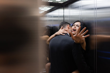 Young sexy couple making love in elevator on blurred foregroundの写真素材