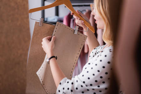 showroom proprietor holding hanger with templates on blurred foregroundの写真素材