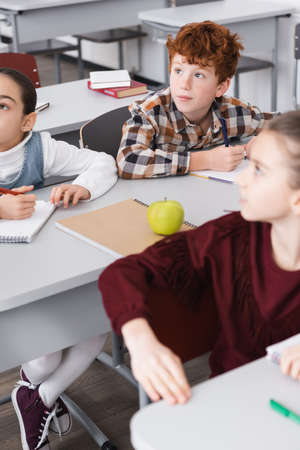 concentrated pupils sitting at desks in classroom during lessonの写真素材