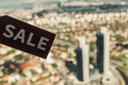 card with sale lettering with aerial view of city on blurred backgroundの写真素材