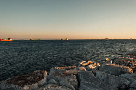 cloudless sky over barges on sea, and stone seacoastの写真素材