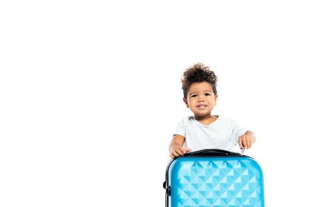 cheerful african american child opening suitcase isolated on whiteの写真素材