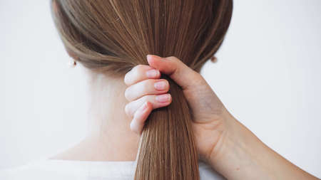 cropped view of woman touching healthy hair of model isolated on whiteの写真素材