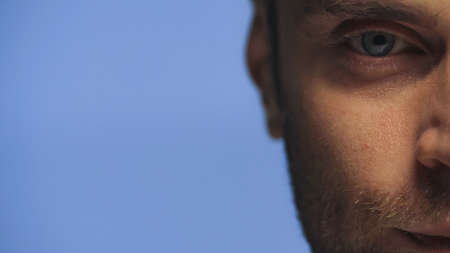 cropped view of man looking ta camera isolated on blueの写真素材