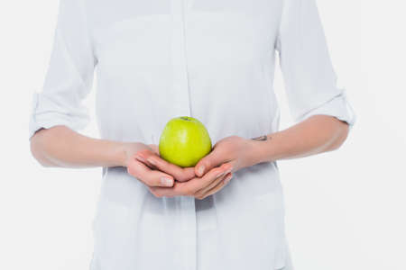 Cropped view of woman in shirt holding apple isolated on whiteの写真素材