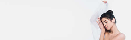 Brunette woman with naked shoulders holding cloth isolated on white, bannerの写真素材