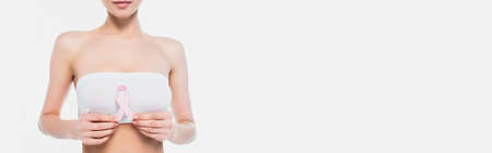 Cropped view of woman in bra holding ribbon of breast cancer awareness isolated on white, bannerの写真素材