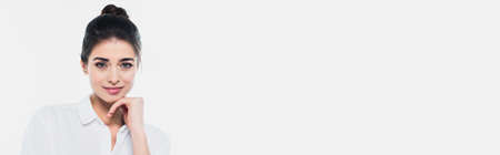 Brunette woman smiling at camera isolated on white, bannerの写真素材