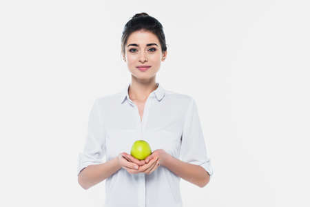 Young woman in shirt holding fresh green apple isolated on whiteの写真素材