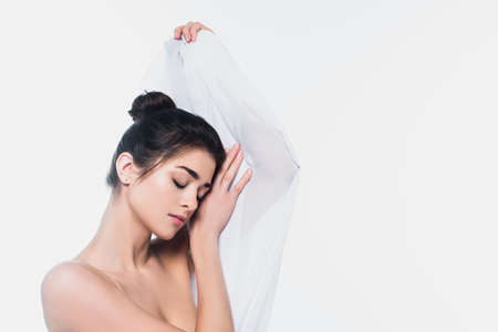 Young woman with naked shoulders holding cloth isolated on whiteの写真素材