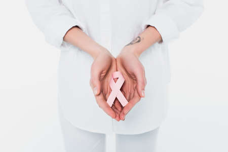 Cropped view of woman holding ribbon of breast cancer awareness isolated on whiteの写真素材