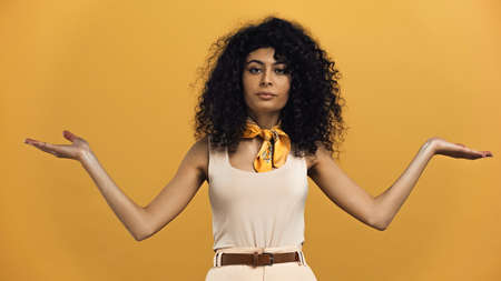 Young hispanic woman pointing with hands isolated on yellowの写真素材