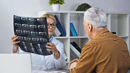 doctor showing x-ray to patient during consultation in hospitalの写真素材
