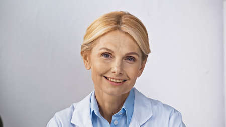 mature, blonde doctor smiling at camera in hospitalの写真素材