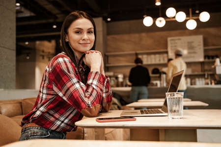 happy freelancer sitting on couch in cafeの写真素材