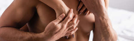 Cropped view of woman touching chest of shirtless man at home, bannerの写真素材