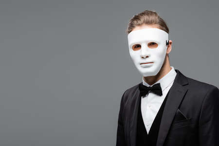 young businessman in face mask looking at camera isolated on grayの写真素材
