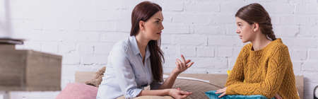 mother gesturing while talking with teenage daughter in bedroom, banner