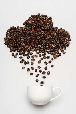 flat lay with coffee beans in cloud shape and rain near cup on white