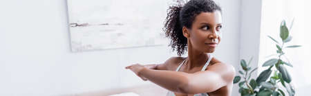 African american sportswoman exercising at home, banner