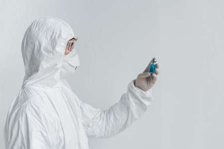 Scientist looking at jar with vaccineの写真素材