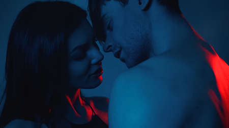 sexy woman and man standing close on blue