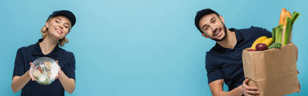 couple of joyful interracial couriers with food smiling at camera isolated on blue, bannerの写真素材