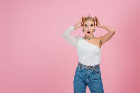 amazed woman wearing crown isolated on pinkの写真素材