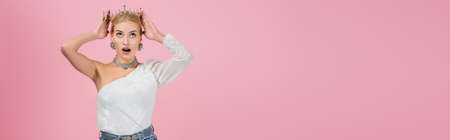 amazed woman wearing crown isolated on pink, bannerの写真素材