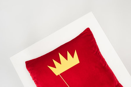 top view of paper crown on stick and red pillow isolated on grayの写真素材
