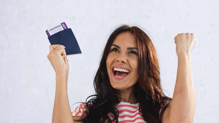 excited woman holding passport with air ticketの写真素材