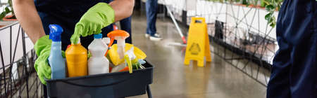 Cropped view of cleaner opening detergent in office, bannerの写真素材