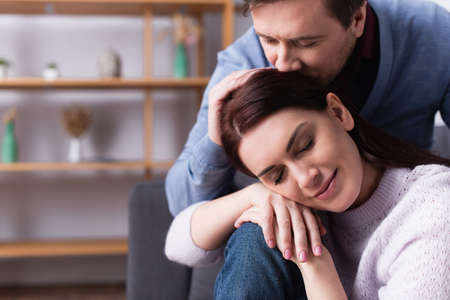Man kissing head of woman with closed eyesの写真素材