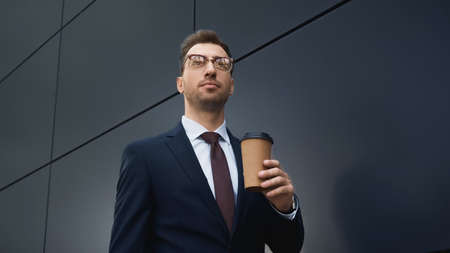 businessman in formal wear holding coffee to go outsideの写真素材
