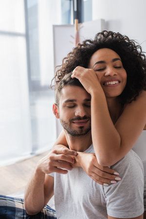 happy african american woman hugging bearded boyfriendの写真素材